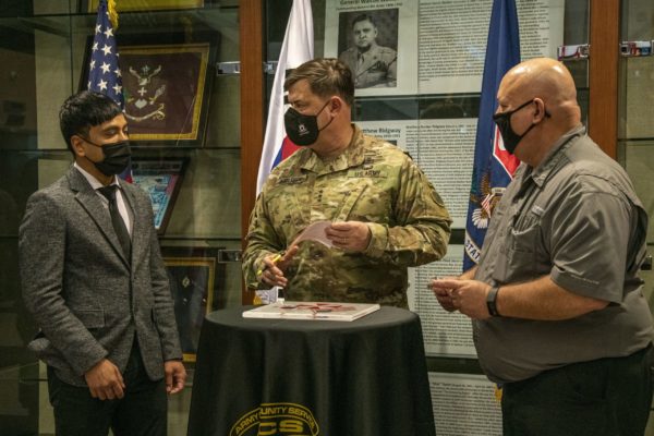 Army general gives donation check to AER reps.