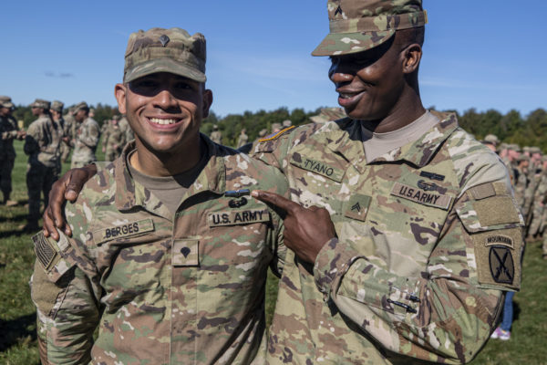Two U.S. Soldiers in uniform pose for a photo, one pointing at the other.